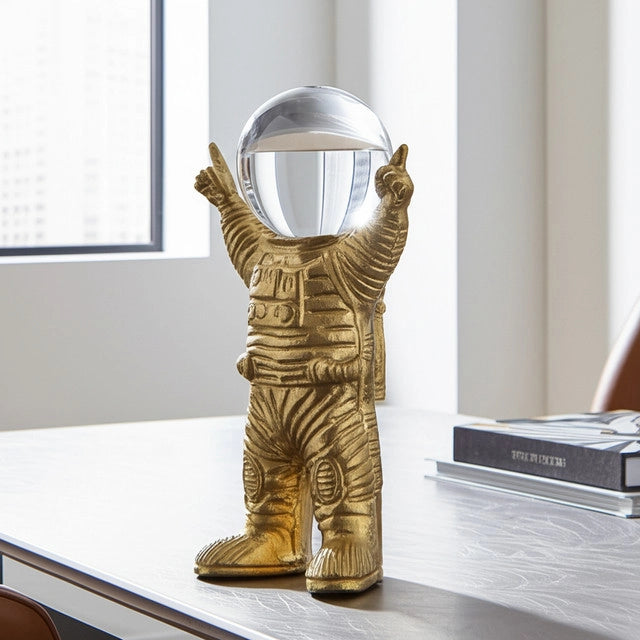 ESCULTURA DECORATIVA ASTRONAUTA METAL COLOR ORO CON ESFERA DE CRISTAL