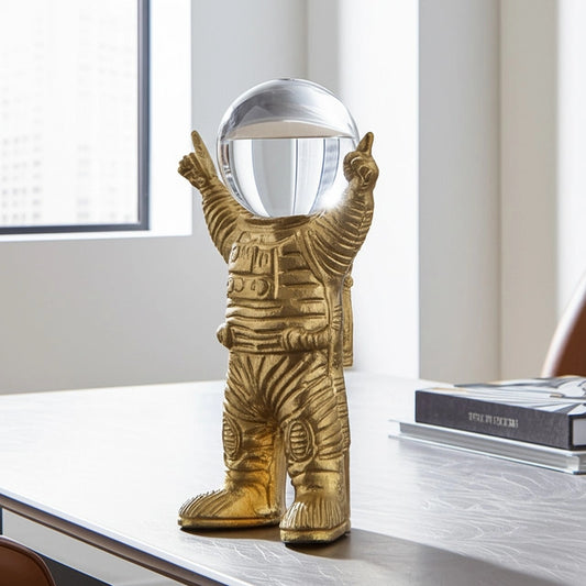 ESCULTURA DECORATIVA ASTRONAUTA METAL COLOR ORO CON ESFERA DE CRISTAL